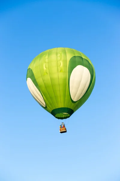 Green hot air balloon on blue sky background — Stock Photo, Image