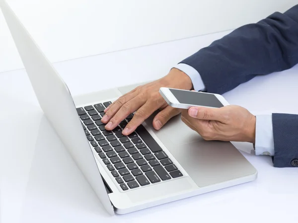 Biznesmen ręce trzymając telefon z laptopem — Zdjęcie stockowe