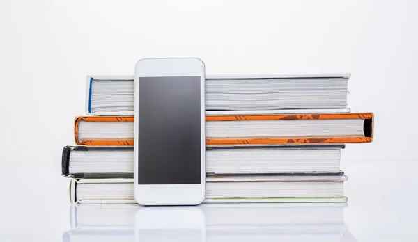 Cellulare accanto al gruppo di libro su sfondo bianco — Foto Stock
