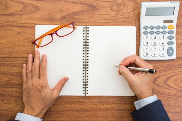 Businessman hand holding pen with blank notebook — Stock Photo, Image