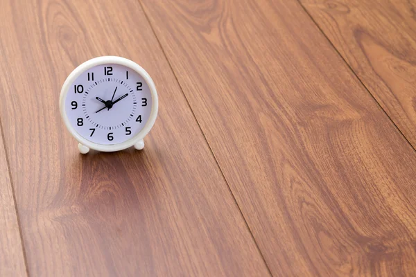 Reloj blanco sobre fondo de madera — Foto de Stock