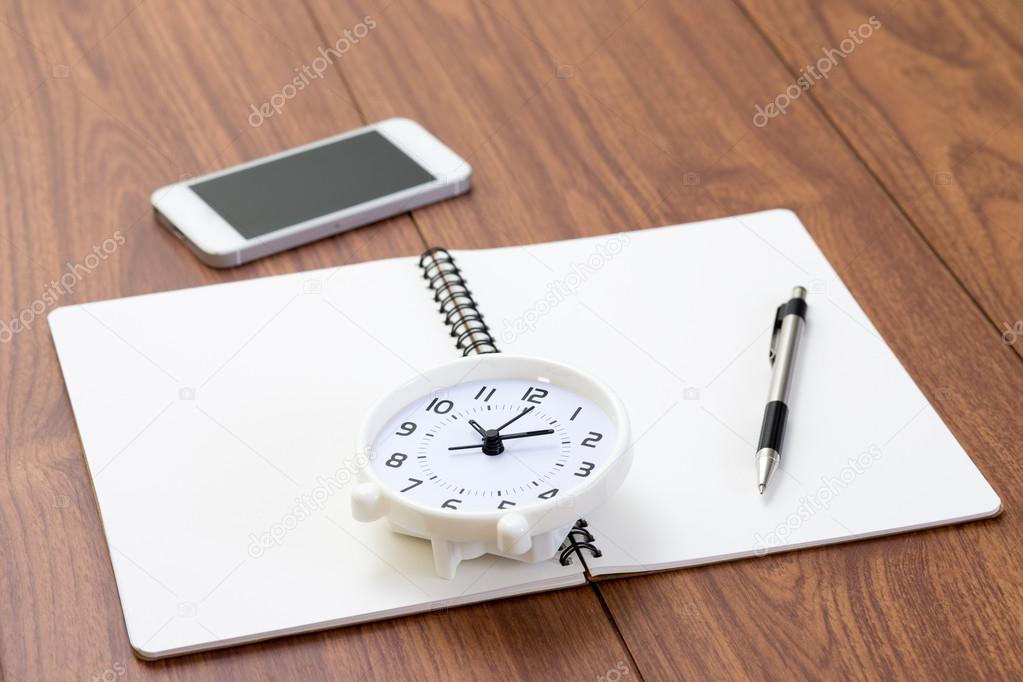 Notebook and office accessories on wood background