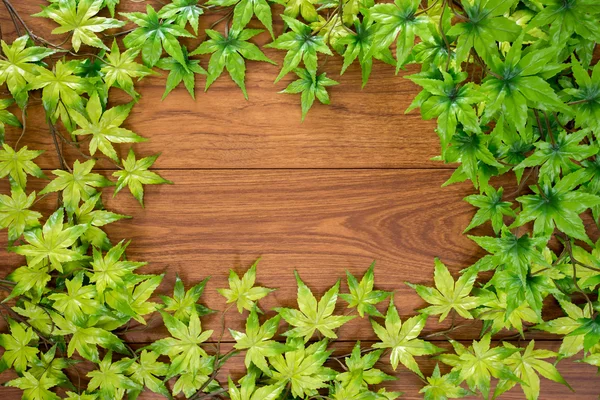 Moldura de folhas de bordo no fundo de madeira — Fotografia de Stock