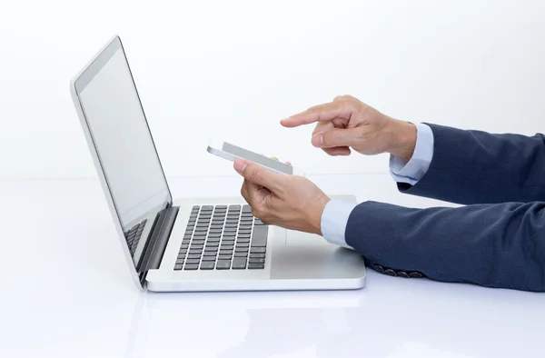 Businessman hand holding mobile phone with laptop computer — Stock Photo, Image