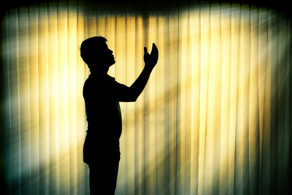 シルエットの男は光線効果を祈る — ストック写真