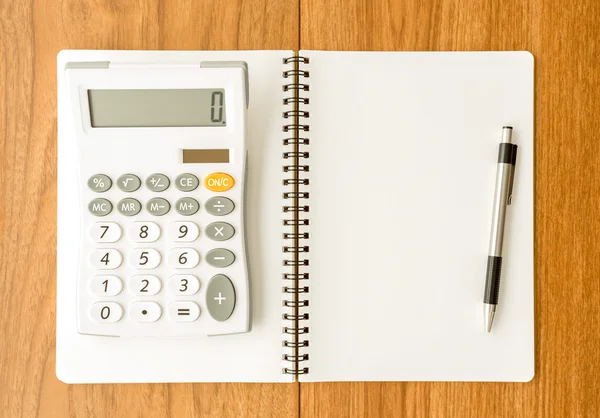 Blank notebook and calculator on wood background — Stock Photo, Image