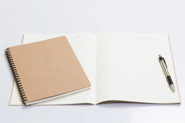 Cuaderno en blanco con un bolígrafo sobre mesa blanca — Foto de Stock