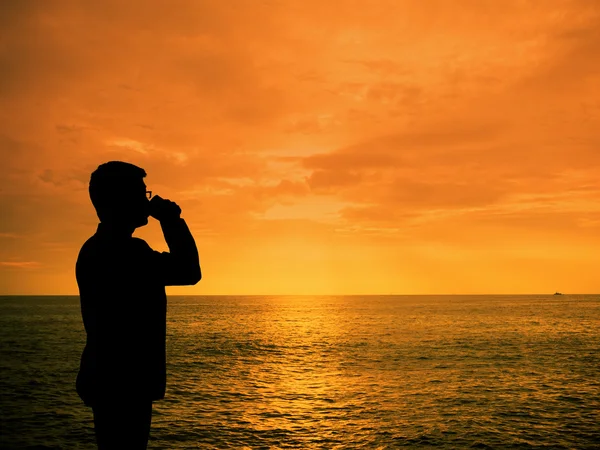 Silhouette Mann Reißverschluss Kaffee am Sonnenuntergang Strand — Stockfoto