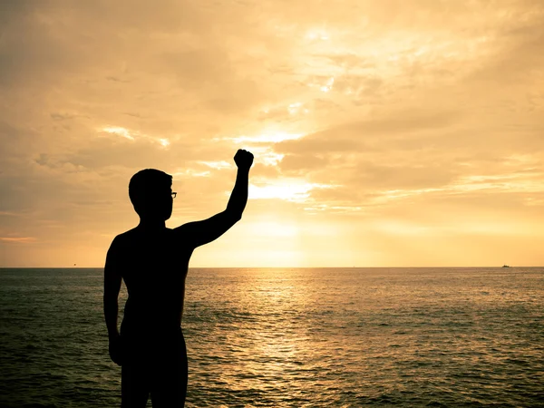 Sylwetka człowieka Wyświetlono rękę w sunset beach — Zdjęcie stockowe