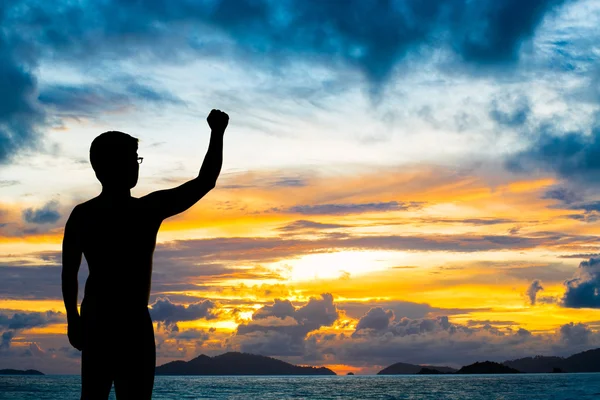 Silhouette Mann zeigt seine Hand am Sonnenuntergang Strand — Stockfoto