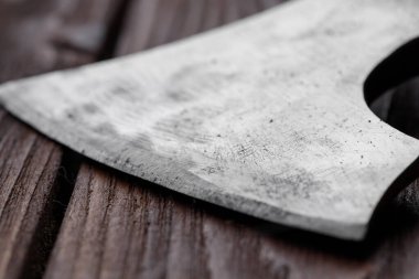 Kahverengi ahşap arka planda bir balta bıçağı.