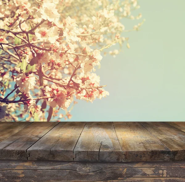 Деревянный деревенский стол перед весенней белой сакурой цветет дерево. Vintage filtered image. демонстрация продукции и концепция пикника — стоковое фото