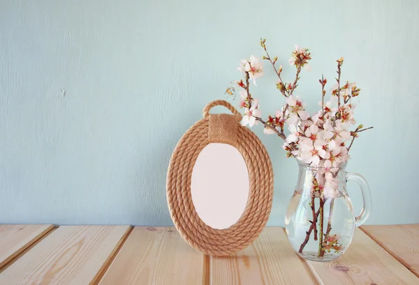 Vintage blank frame next to white spring flowers. selective focus. template, ready to put photography — Stock fotografie