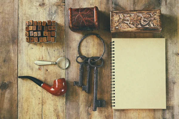 Dedektif kavramı. Özel Dedektif araçlar: büyüteç cam, eski anahtarları, İçilmeyen boru, defter. Üstten Görünüm. Vintage filtre uygulanmış görüntü — Stok fotoğraf