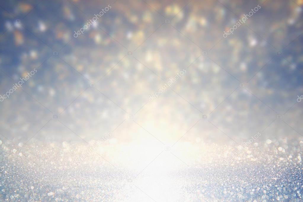 glitter vintage lights background. gold, silver, blue and white. de-focused.