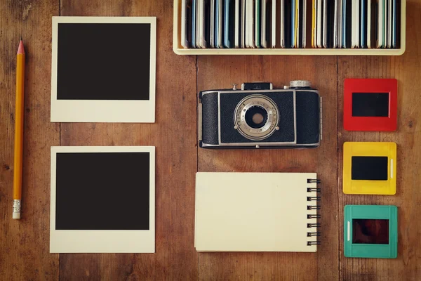 Ovansida av vintage kamera och gamla bilder ramar över träbord bakgrund — Stockfoto