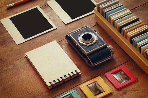 Ansicht von Vintage-Kamera und alten Diarahmen über Holztischhintergrund — Stockfoto