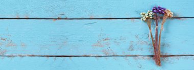 Web sitesi banner arka plan eski mavi ahşap arka plan üzerinde kurutulmuş renkli çiçeklerin