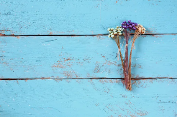 Image de vue de dessus de fleurs colorées séchées sur vieux fond bleu en bois — Photo