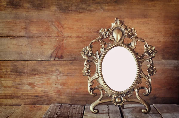 Marco de estilo victoriano en blanco antiguo sobre mesa de madera. vintage imagen filtrada. plantilla, listo para poner la fotografía — Foto de Stock