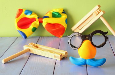 Bıyık maskesi ve şenlikli oyuncak ahşap masa üzerinde komik gözlükler. seçici odak