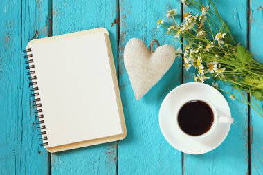 Üstten Görünüm görüntü papatya çiçek, boş defter ve kumaş kalbinde yanında kahve mavi ahşap tablo.