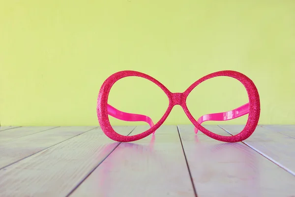 木製のテーブルに祭りのレトロなピンク眼鏡 — ストック写真