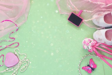 Küçük kız parti kıyafeti üst görünümü: beyaz ayakkabı, taç ve küçük tebeşir tahtası yanında değnek çiçekleri. nedime veya peri kostümü. glitter kaplama