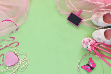 Küçük kız parti kıyafeti üst görünümü: beyaz ayakkabı, taç ve küçük tebeşir tahtası yanında değnek çiçekleri. nedime veya peri kostümü