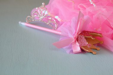Small girls party outfit: crown and wand on wooden table. bridesmaid or fairy costume