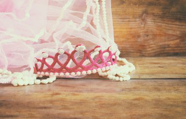 Small girls party outfit: crown and vail on wooden table. bridesmaid or fairy costume.