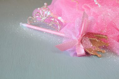 Small girls party outfit: crown and wand on wooden table. bridesmaid or fairy costume