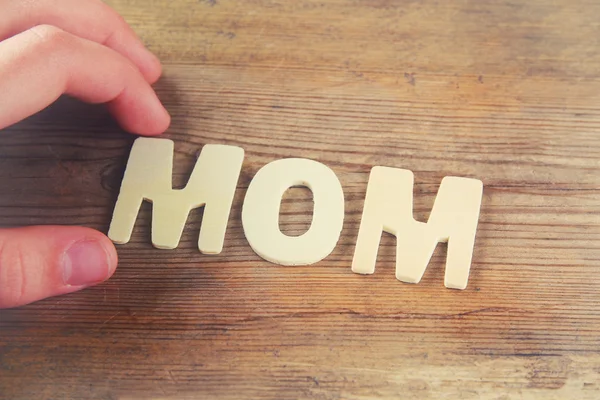 Palavra MOM feito com letras de madeira bloco no fundo de madeira. vintage filtrado e tonificado — Fotografia de Stock