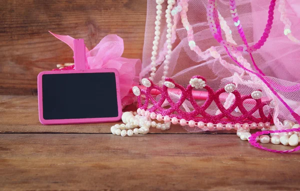 Kleines Mädchen Party-Outfit: Krone und Zauberstab Blumen neben leere kleine Kreidetafel auf Holztisch. Brautjungfer oder Märchenkostüm — Stockfoto