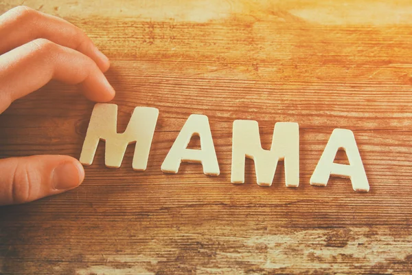 Word MAMA made with block wooden letters on wooden background. vintage filtered and toned — Stockfoto