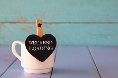 cup of coffee and little heart shape chalkboard with the phrase: WEEKEND LOADING. clipart