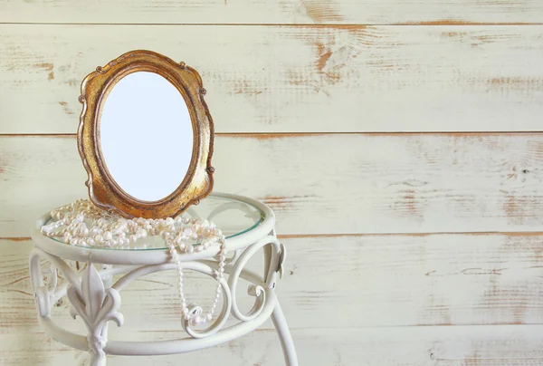 Antike leere Rahmen im Vintage-Stil und weiße Perlen auf elegantem Tisch. Vorlage, bereit zum Fotografieren. Jahrgang gefiltert — Stockfoto