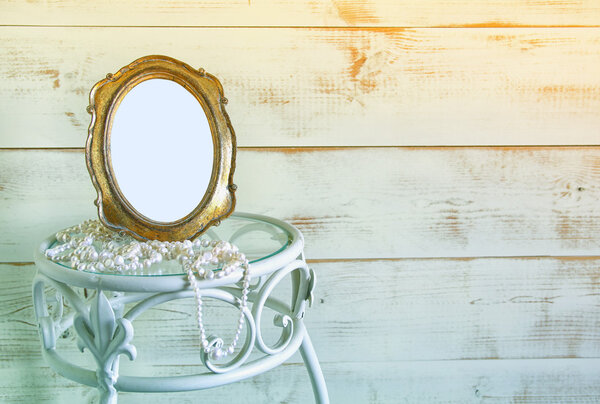 Antique blank vintage style frame and white pearls on elegant table. template, ready to put photography. vintage filtered