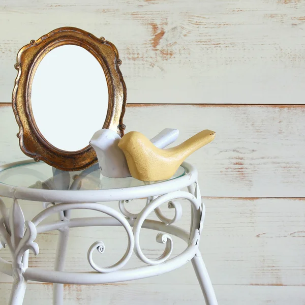 Antieke leeg vintage stijl frame en paar van hout decor vogels op vintage tafel. sjabloon, klaar om fotografie — Stockfoto