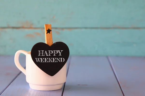 Xícara de café e pouco chalkboard forma de coração com a frase: WEEKEND HAPPY . — Fotografia de Stock