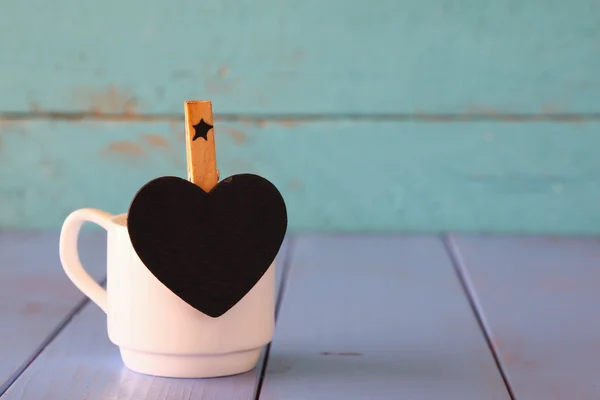 Cup of coffee and little heart shape chalkboard — Stock Photo, Image