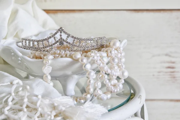 Image of white pearls necklace and diamond tiara on vintage table. selective focus — Stock Photo, Image