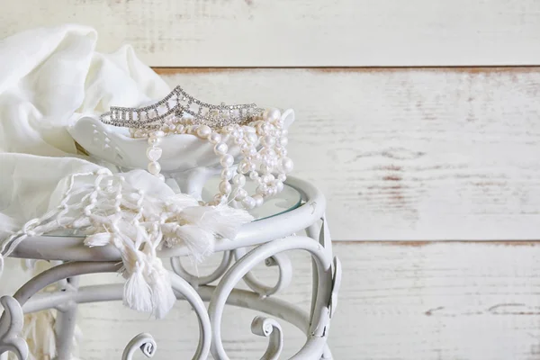 Imagen de collar de perlas blancas y diadema de diamante en mesa vintage. enfoque selectivo —  Fotos de Stock