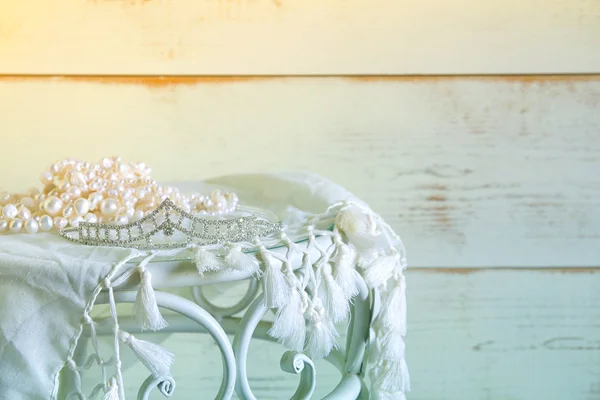 Image of white pearls necklace and diamond tiara on vintage table. selective focus — Stock Photo, Image