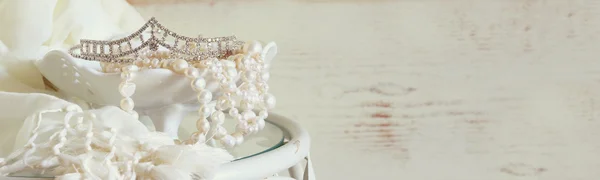 Website banner background of white pearls necklace and diamond tiara on vintage table. imagem tonificada. foco seletivo — Fotografia de Stock