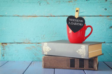 ifade ile biraz kalp şekli tebeşir ile kahve fincan: Hafta sonu Yükleme ve eski kitap yığını.