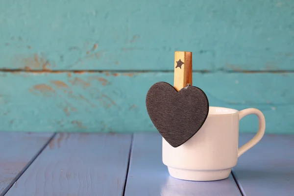 Cup of coffee and little heart shape chalkboard — Stock Photo, Image