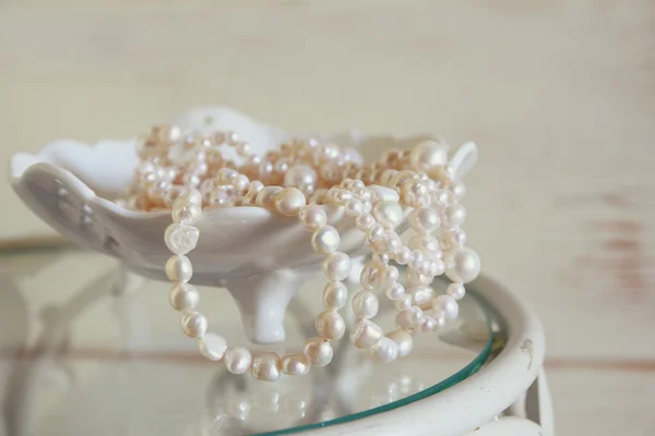 White pearls necklace on vintage table. selective focus — Stock Photo, Image