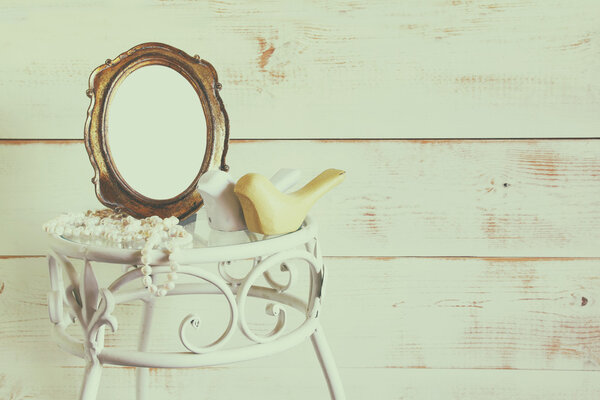 Antique blank vintage style frame and white pearls on elegant table. template, ready to put photography. vintage filtered and toned