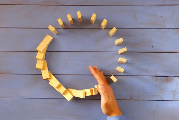 Una mano maschile ferma l'effetto domino. immagine retrò stile esecutivo e concetto di controllo dei rischi — Foto Stock